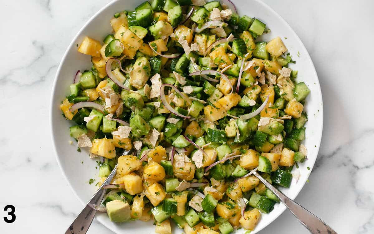 Salad tossed with dressing in a bowl.