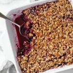 Mixed berry crumble in a dish with a spoon.