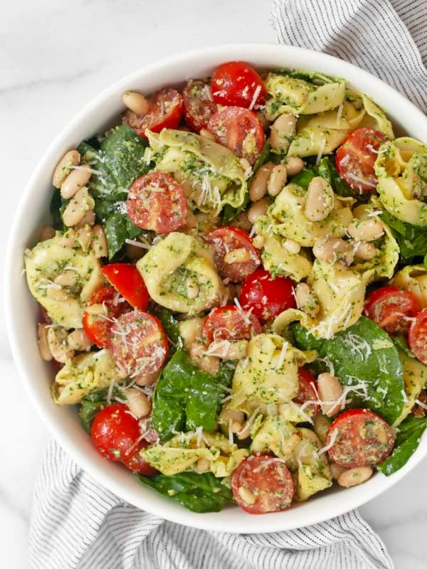 Pesto tortellini pasta salad in a bowl.