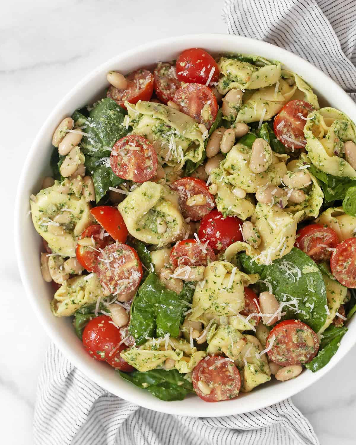 Pesto tortellini pasta salad in a bowl.