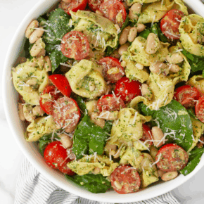 Pesto tortellini pasta salad in a bowl.