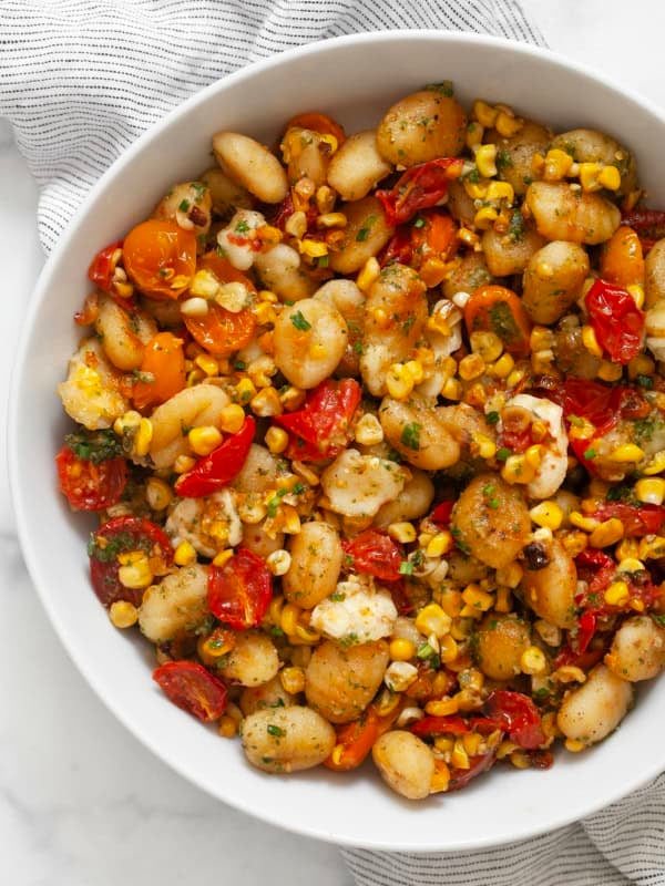 Sheet pan gnocchi with tomatoes and corn in a bowl.