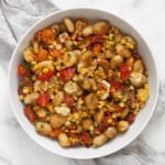 Sheet pan gnocchi with tomatoes and corn in a bowl.