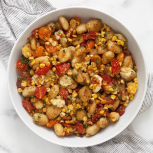 Sheet pan gnocchi with tomatoes and corn in a bowl.