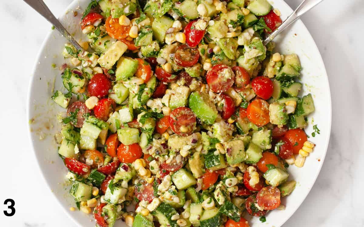 Salad ingredients tossed together in a large bowl.
