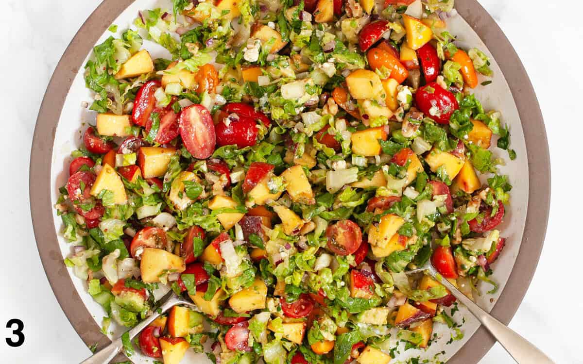 Salad tossed with vinaigrette in a large bowl.