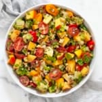 Chopped salad with peaches and tomatoes in a bowl.