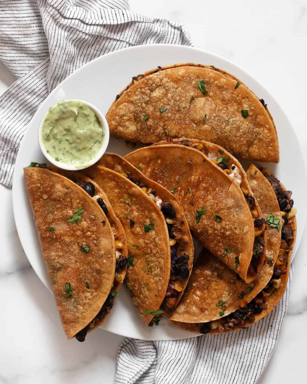 Crispy corn tacos on a plate.