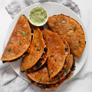 Crispy corn tacos on a plate.