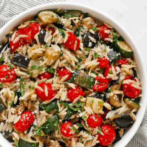 Roasted eggplant, zucchini and tomato orzo in a bowl.
