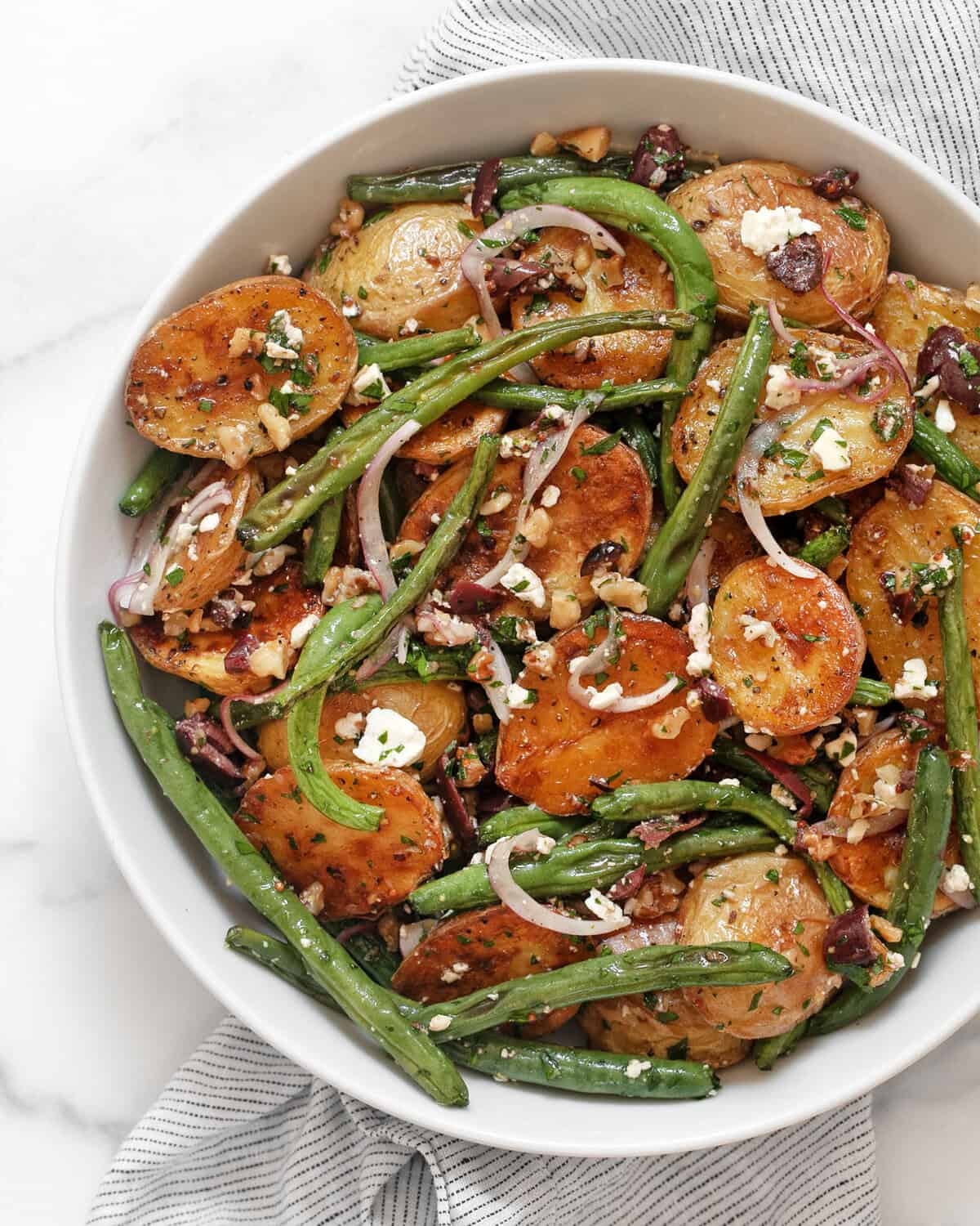 Roasted potato and green bean salad in a bowl.