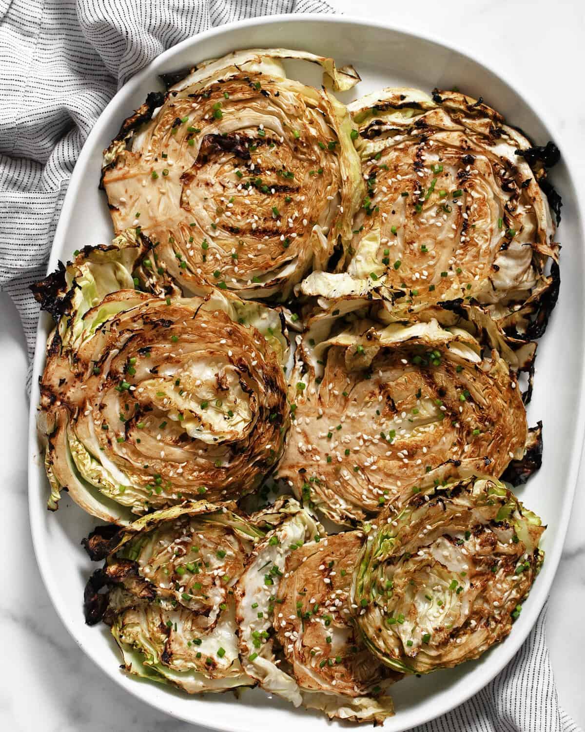 Grilled cabbage steaks on a serving platter.