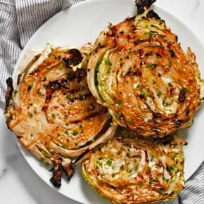 Grilled cabbage steaks on a plate.
