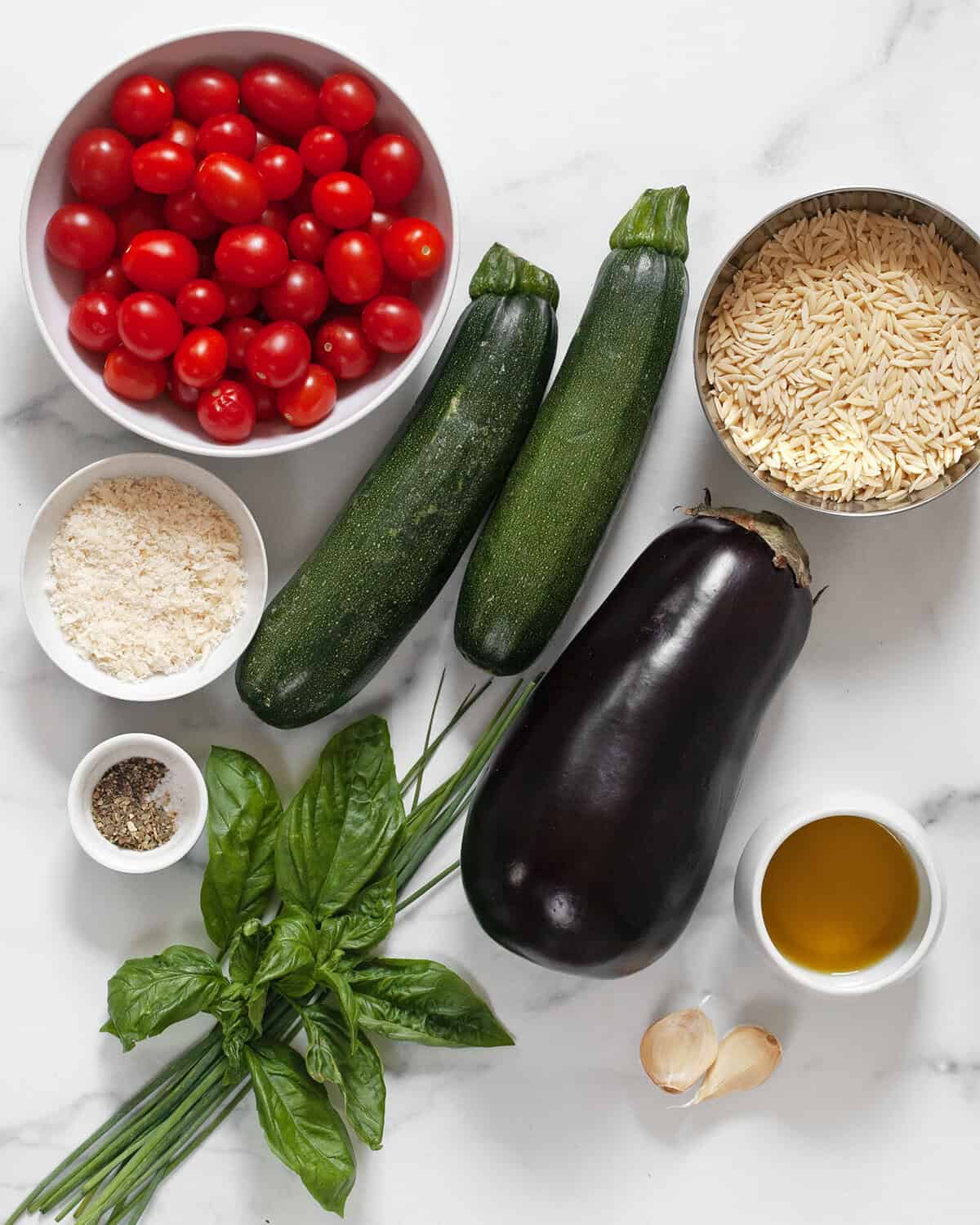 Ingredients including eggplant, zucchini, tomatoes, orzo, basil, chives, parmesan, olive oil, italian, seasoning, garlic, salt and pepper.