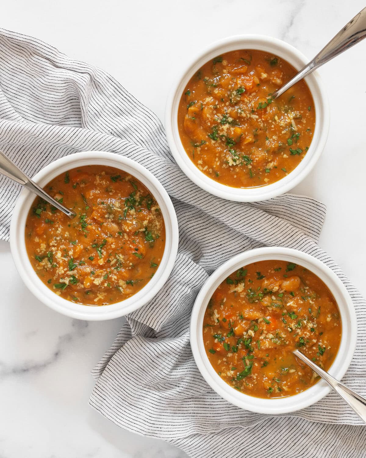 Three bowls of pumpkin soup.