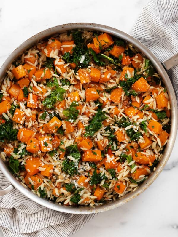 Roasted butternut squash kale orzo in a pan.