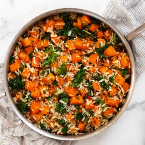 Roasted butternut squash kale orzo in a pan.