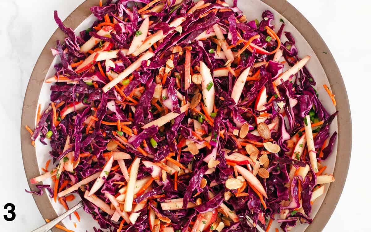 Salad tossed with dressing in a large bowl.