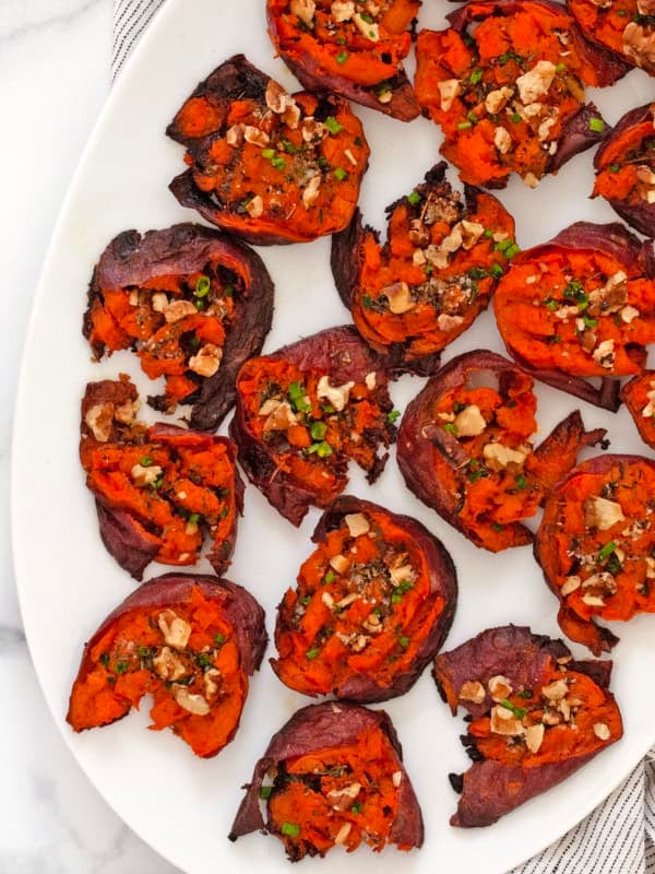 Smashed sweet potatoes on a serving plate.