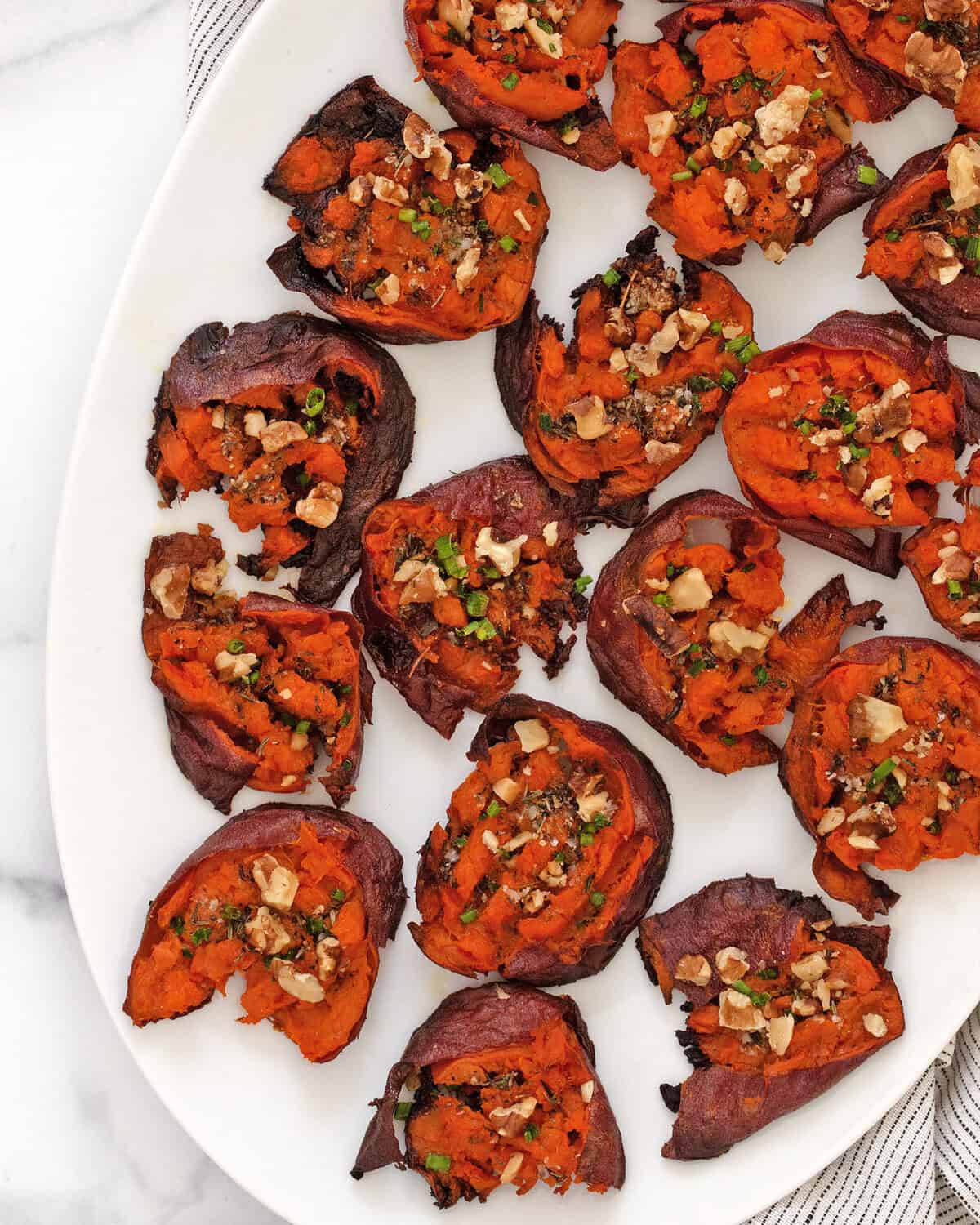 Smashed sweet potatoes on a serving plate.