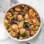 Sheet pan gnocchi with white beans, kale and red onions in a bowl.