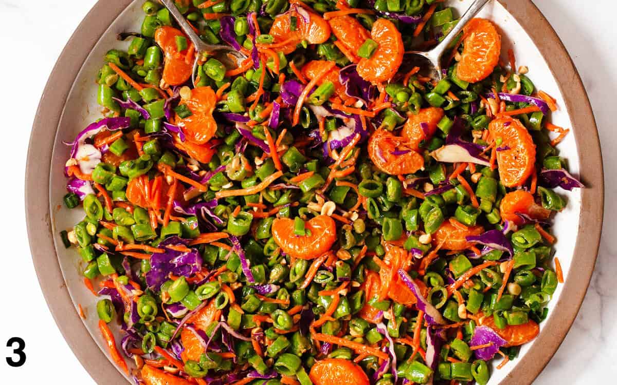 Salad tossed with dressing in a large bowl.