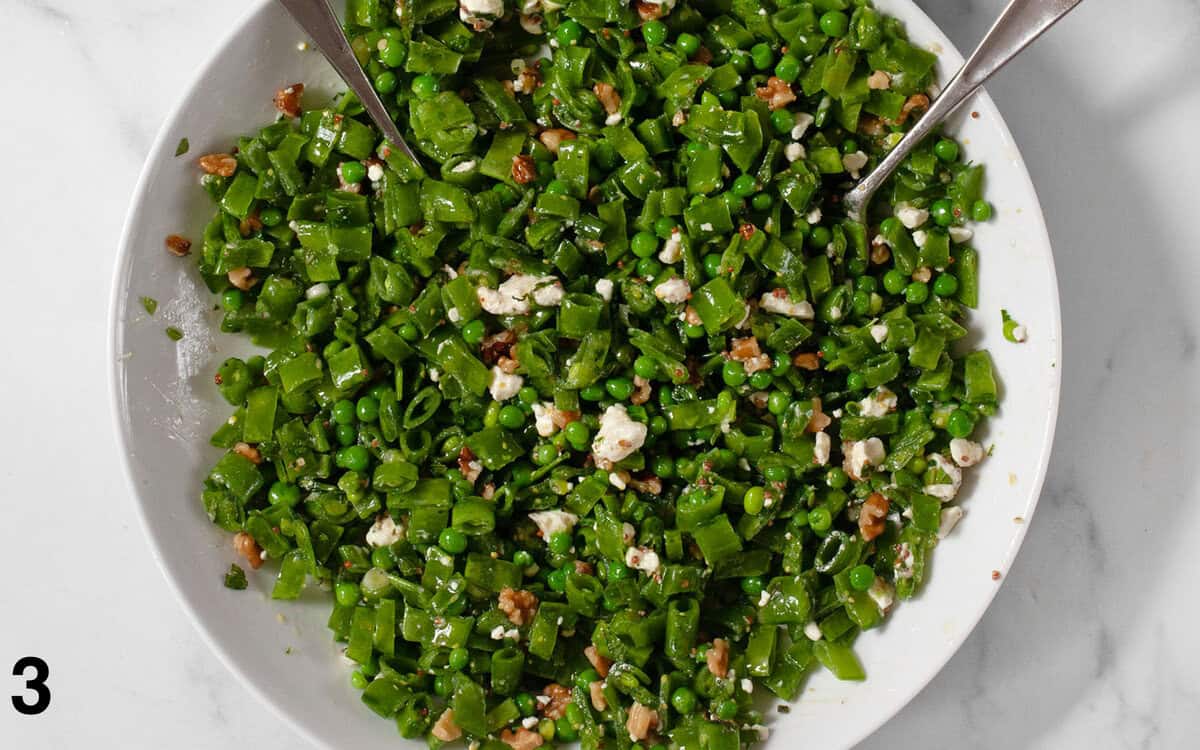 Salad tossed with dressing in a large bowl.