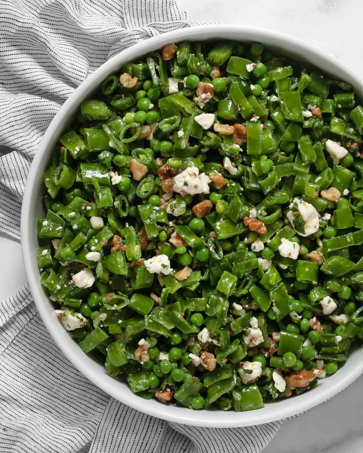 Three pea salad in a large serving bowl.