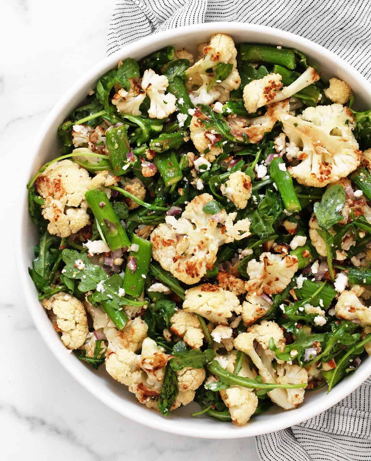 Roasted asparagus cauliflower salad in a bowl.