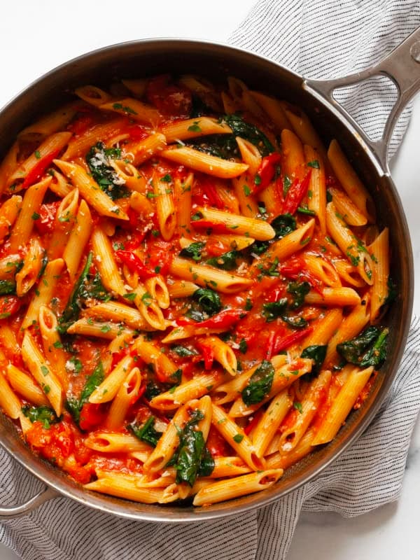 Spinach tomato pasta in a skillet.