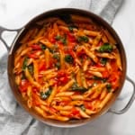 Spinach tomato pasta in a skillet.