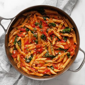 Spinach tomato pasta in a skillet.