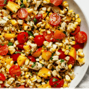 Grilled halloumi salad with corn, tomatoes and peaches in a bowl.