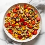 Grilled halloumi salad with corn, tomatoes and peaches in a bowl.